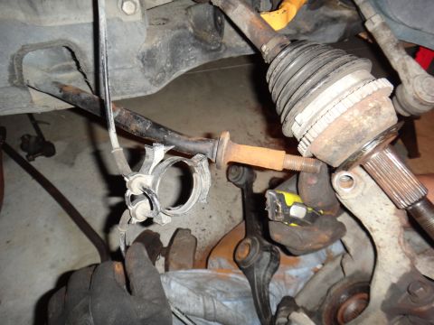 1993 Ford Taurus - A close-up view of a vehicle's suspension system, showing various metal parts and a yellow measuring tape.