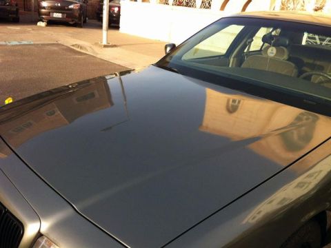 2001 Mercury Grand Marquis - Hood and windshield of a 2001 Mercury Grand Marquis, with reflections visible.