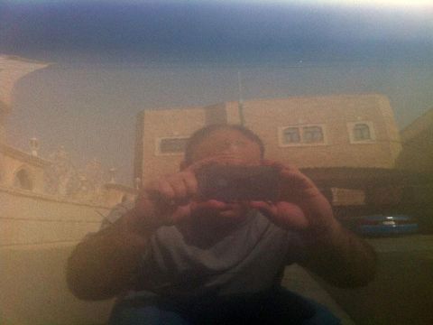 2001 Mercury Grand Marquis - A person's reflection is visible in the polished surface of a car, with a building and sky in the background.