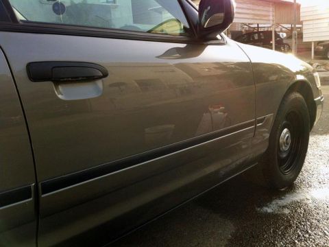 2001 Mercury Grand Marquis - The side of a car is shown with a reflection of buildings in the door panel.