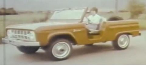 1973 Ford Bronco - A first-generation Ford Bronco is driven by a person in this outdoor scene.