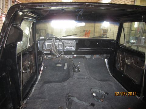 1979 Ford Bronco - The interior of a 1979 Ford Bronco is shown with new carpet and exposed door panels, indicating ongoing restoration work.