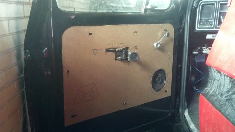 1979 Ford Bronco - Interior view of a car door panel, showing a speaker, window crank, and exposed hardware, with a Supermotors watermark.