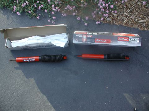 1992 Mercury Grand Marquis - Two Edelbrock shock absorbers are displayed on a dark surface next to their packaging.