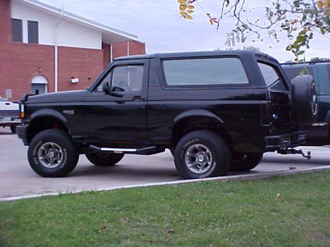 1995 Ford Bronco - This black 1995 Ford Bronco is seen from the side, a spare tire mounted on the rear door.
