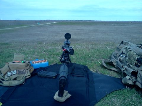 1996 Ford Bronco - A sniper rifle is set up on a tripod at a shooting range, with ammunition and gear nearby.