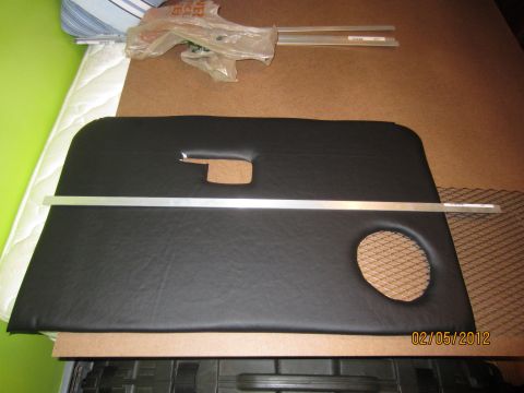 1979 Ford Bronco - A black vinyl door panel, likely for a vehicle interior, is laid out on a surface.