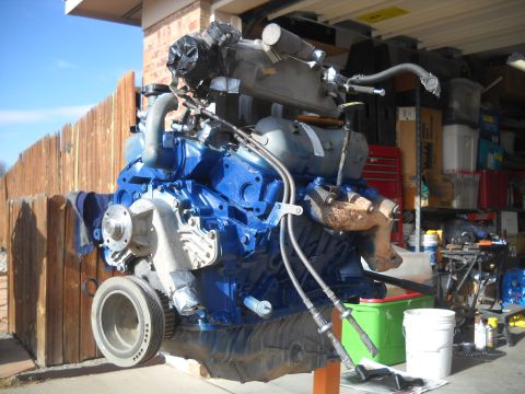 1992 Ford Explorer - A blue engine assembly is displayed outdoors, mounted on an orange stand with a wooden fence in the background.