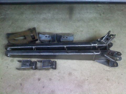 1996 Ford Bronco - Several custom-welded steel suspension components are arranged on a concrete surface.