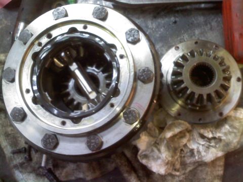 1996 Ford Bronco - Close-up of differential components, including gears and a housing, on a cluttered surface.