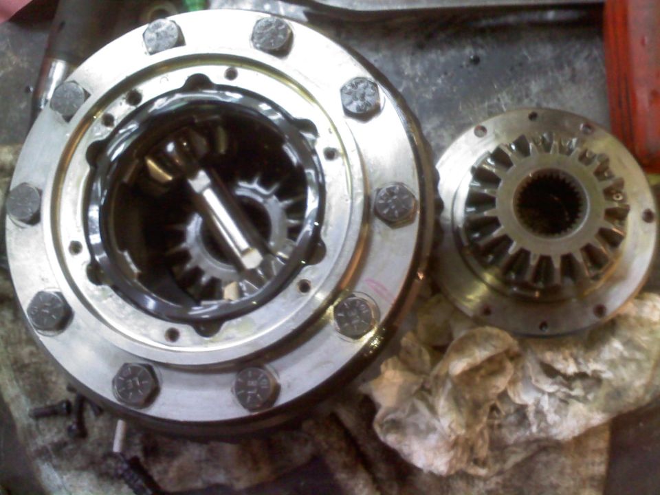 Differential components with gears and bolts on a workbench