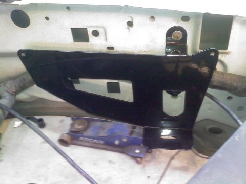 1996 Ford Bronco - Black metal bracket installed in vehicle engine bay, with a jack visible below.