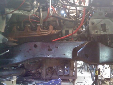 1996 Ford Bronco - Close-up view of a vehicle's engine and frame, highlighting the exhaust manifold and wiring during a build process.