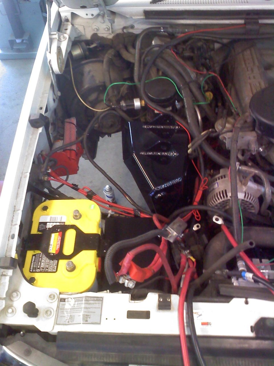 Engine bay with yellow Optima battery and red wiring