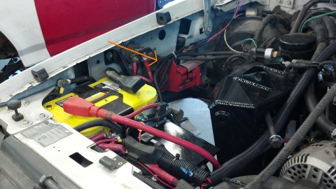 1996 Ford Bronco - Close-up view of a vehicle's engine bay, showing the battery and various electrical components.