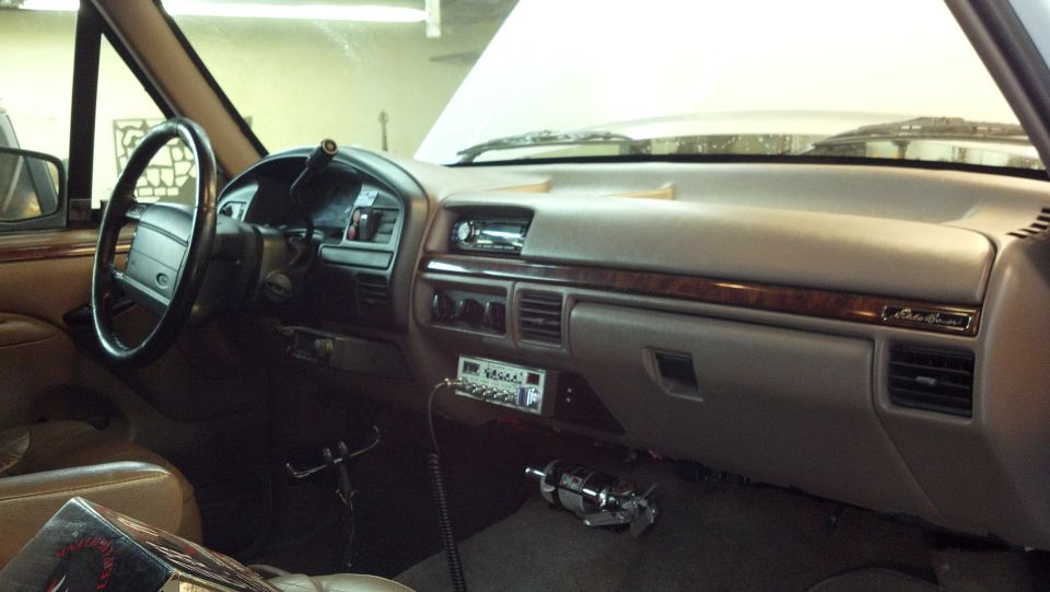 Interior of a truck with a CB radio installed below the dash. Wood trim accents the dashboard