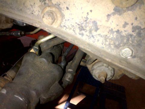 1965 Ford Mustang - Underside view of vehicle brake caliper and suspension components, with brake lines visible.