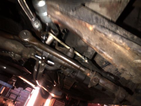 1965 Ford Mustang - Close-up of the steering linkage and frame from underneath a vehicle.