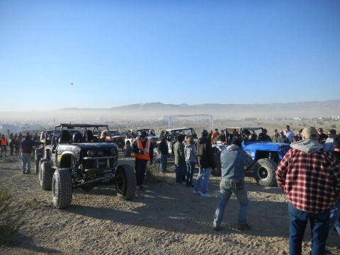 1997 Ford Ranger - Several off-road vehicles are parked on a dirt lot, with a crowd of people milling around them.