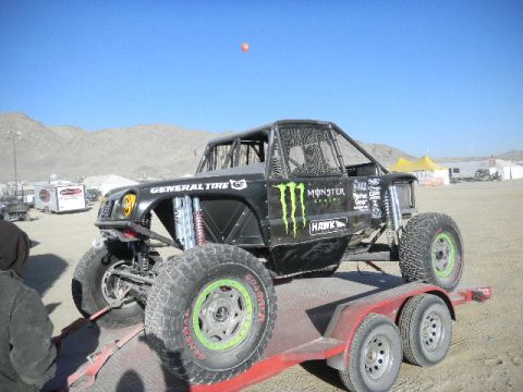 1997 Ford Ranger - A heavily modified off-road buggy with large tires and a roll cage is loaded onto a trailer.