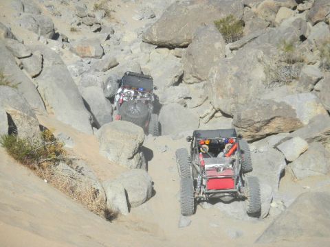 1997 Ford Ranger - Two custom off-road vehicles tackle a challenging rocky terrain, demonstrating their climbing capabilities.