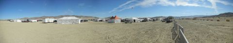 1997 Ford Ranger - A wide panoramic view of a desert encampment with various structures and vehicles scattered across the sandy terrain.