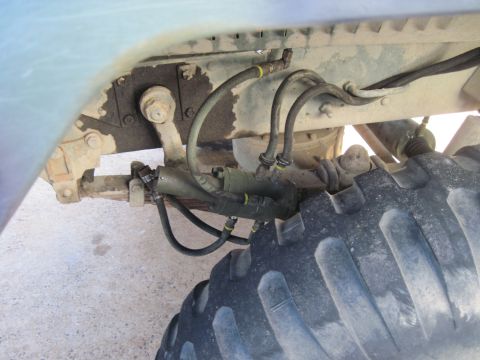2005 Ford Excursion - Detail of a heavy-duty truck's suspension system, including brake lines and leaf springs.