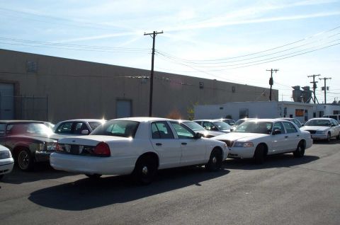 1998 Ford Crown Victoria - The center row, behind the building. Look closely to see the old Pontiac Grand Ville convertible. (large pic)