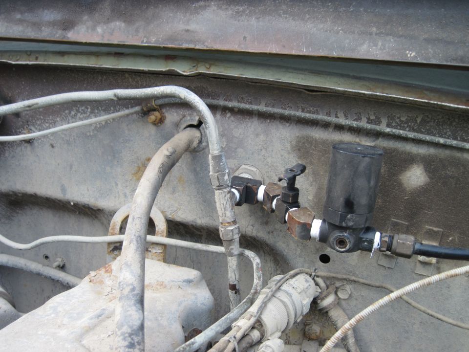 Engine bay plumbing with black canister and valve