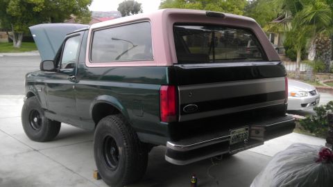 1996 Ford Bronco - 1996 Ford Bronco parked in a driveway with its hood up.