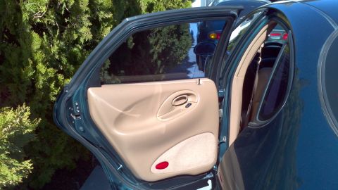 1996 Ford Taurus - Interior view of a 1996 Ford Taurus, showing the tan door panel and tinted windows.