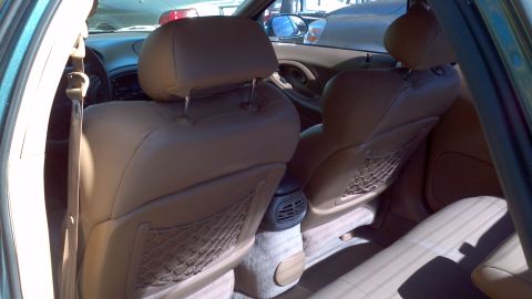 1996 Ford Taurus - Interior view of tan leather seats and dashboard, showing the rear seating area and part of the front.