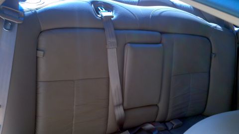 1996 Ford Taurus - The interior of a car shows the back seat with a visible seatbelt and armrest.