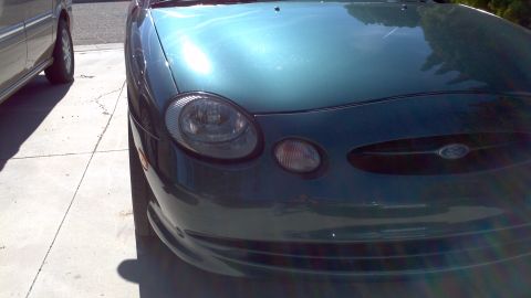 1996 Ford Taurus - Front view of a teal 1996 Ford Taurus parked next to another vehicle.