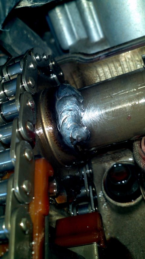 1996 Ford Taurus - This image shows a close-up view of engine components, including a timing chain and camshaft, with a noticeable weld repair.