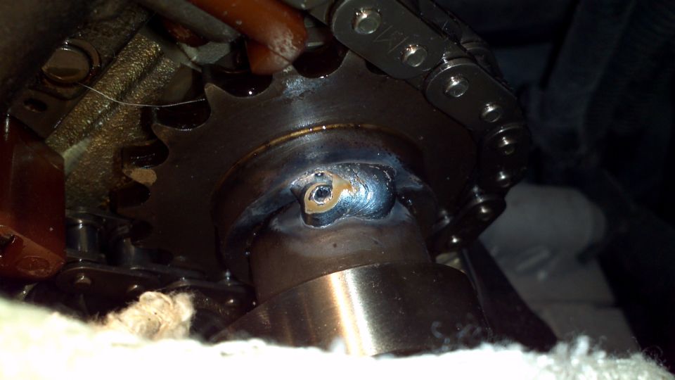 close-up of engine timing chain and sprocket with visible weld repair