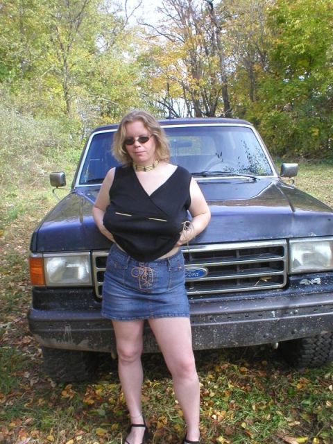 1989 Ford Bronco - Front view of a dark blue/black older Ford truck or SUV with a chrome grille bearing the Ford emblem and a '4x4' badge, parked on grass and…