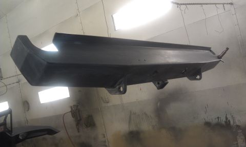 1995 Ford Bronco - Bumper being prepped for paint in a workshop environment.
