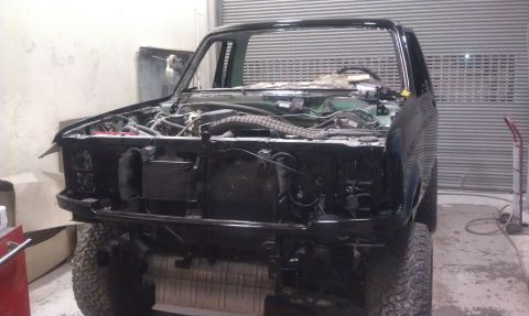 1995 Ford Bronco - Vehicle is in a workshop with the front end disassembled for maintenance or repair.