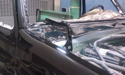 1995 Ford Bronco - The front end of a vehicle is shown with its hood open, revealing the engine bay and parts of the interior, suggesting it is undergoing mai…