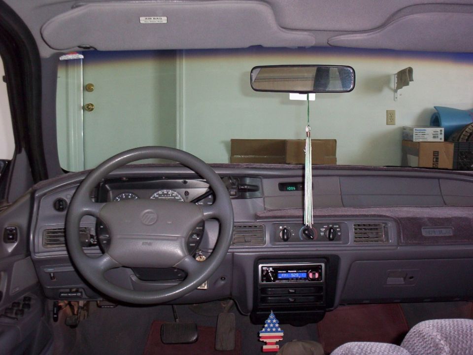 Gray Mercury dashboard and steering wheel viewed from rear seat