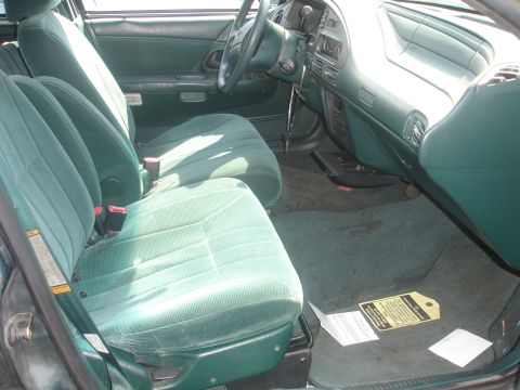 1993 Ford Taurus - The interior of a 1993 Ford Taurus features green fabric seats and a matching dashboard.