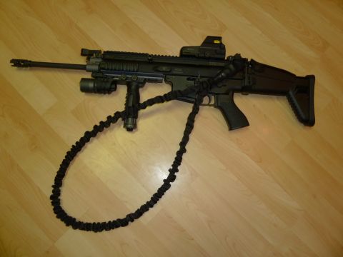 1992 Ford Mustang - A tactical rifle is displayed on a wood-grain surface, equipped with various attachments.