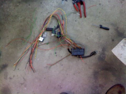 1996 Ford Bronco - A disassembled wiring harness lies on a concrete surface, with tools nearby.