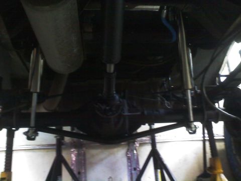 1996 Ford Bronco - Undercarriage view of a vehicle, highlighting suspension components and the driveshaft.