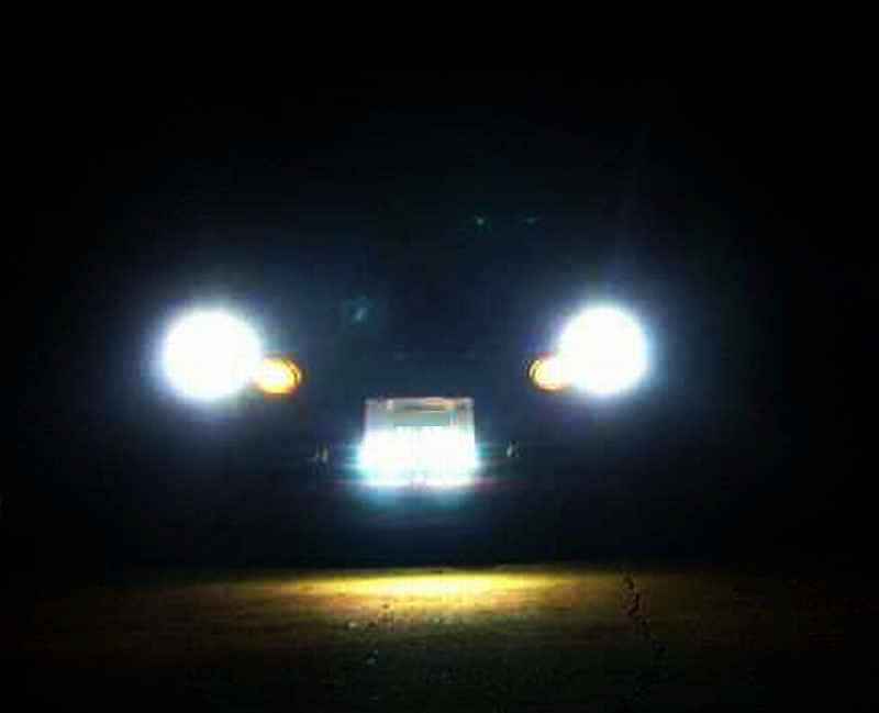 Car headlights and grille illuminated at night