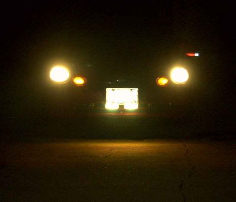1997 Ford Taurus - Rear view of a 1997 Ford Taurus at night, showing illuminated license plate and taillights.