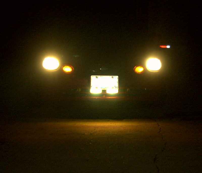1997 Ford Taurus rear with illuminated license plate and taillights at night