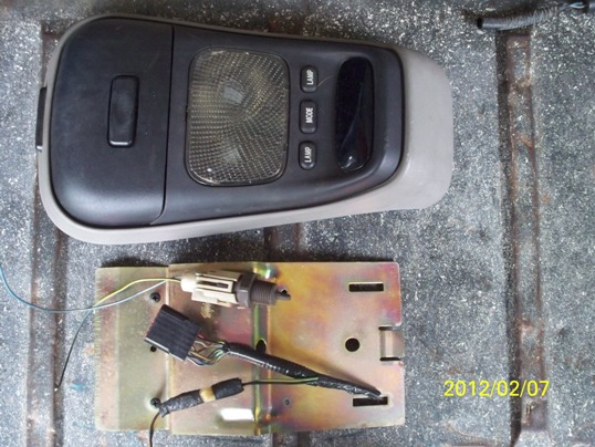 Overhead console light assembly and wiring harness removed from a vehicle