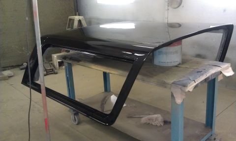 1995 Ford Bronco - A black vehicle door and roof panel are on a cart in what appears to be a workshop.